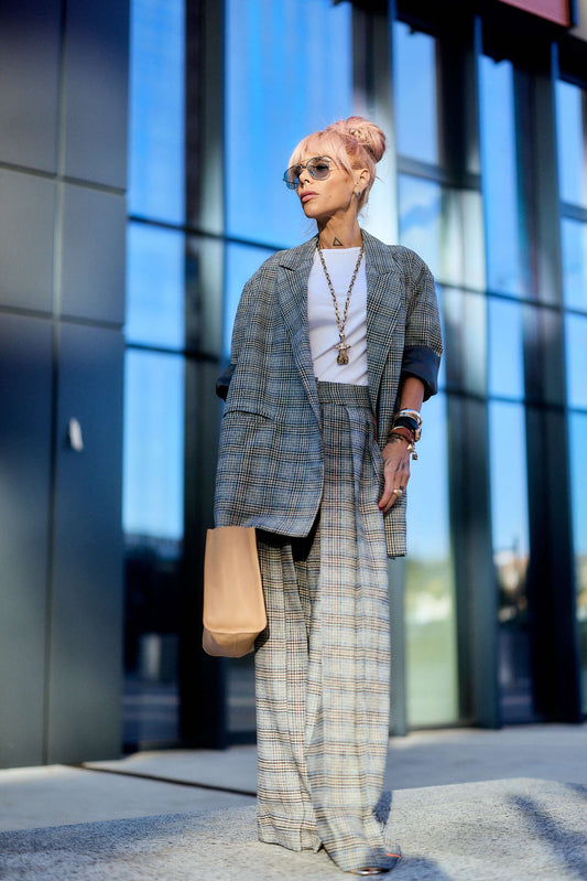 Model wearing an Oversized Checked Blazer with wide-legged trousers and sunglasses in an urban setting.