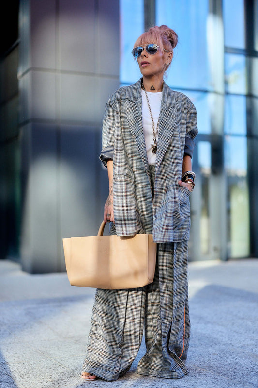 Oversized Checked Blazer worn with relaxed pants and a large beige handbag, featuring sunglasses and a modern urban look.