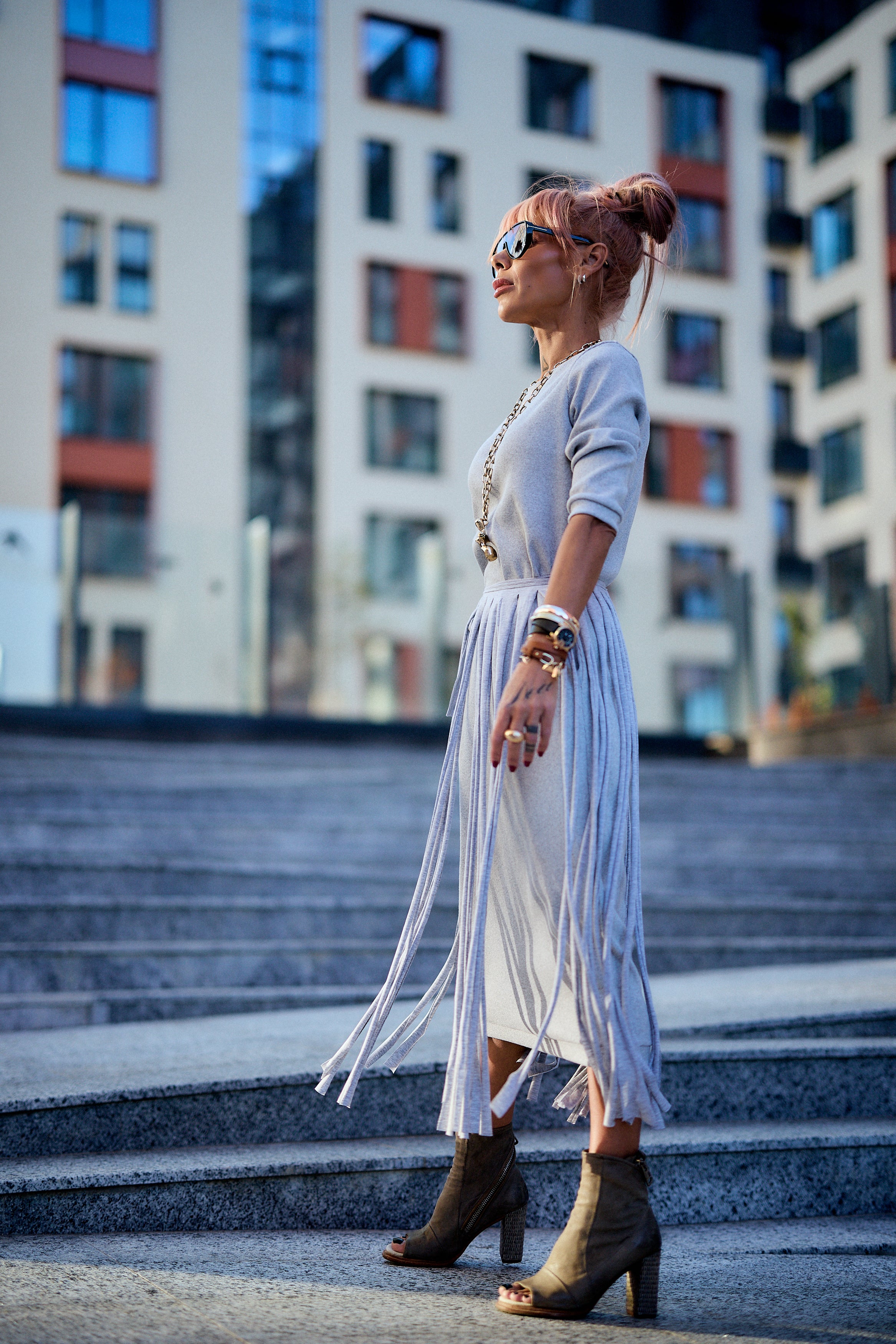 Woman wearing a Grey Fringe Midi Dress, showcasing dramatic fringe panels and stylish footwear.