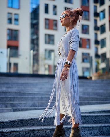 Woman wearing a Grey Fringe Midi Dress, showcasing dramatic fringe panels and stylish footwear.