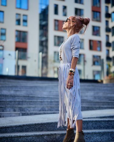 Model wearing a Grey Fringe Midi Dress, showcasing its dramatic fringe and high-waisted silhouette in an urban setting.