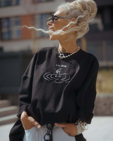 Black Oversized “I’m Fine” Graphic T-Shirt worn by a stylish model outdoors, emphasizing its unique design.