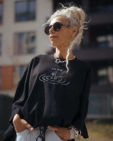 Black Oversized “I’m Fine” Graphic T-Shirt worn by a model outdoors with sunglasses.