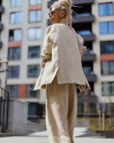 Person wearing a beige suit walking in an urban setting