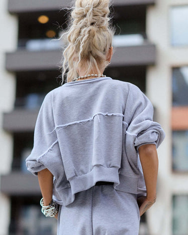 Back view of a model wearing a Grey Relaxed Lounge Set in an urban setting, showcasing a cropped top and relaxed pants.
