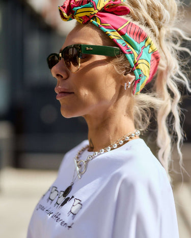 Woman wearing a Statement Printed Headband with bold print, styled with sunglasses and a trendy outfit.