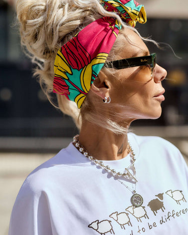 Woman wearing a vibrant Statement Printed Headband with floral print, paired with a casual t-shirt and accessories.