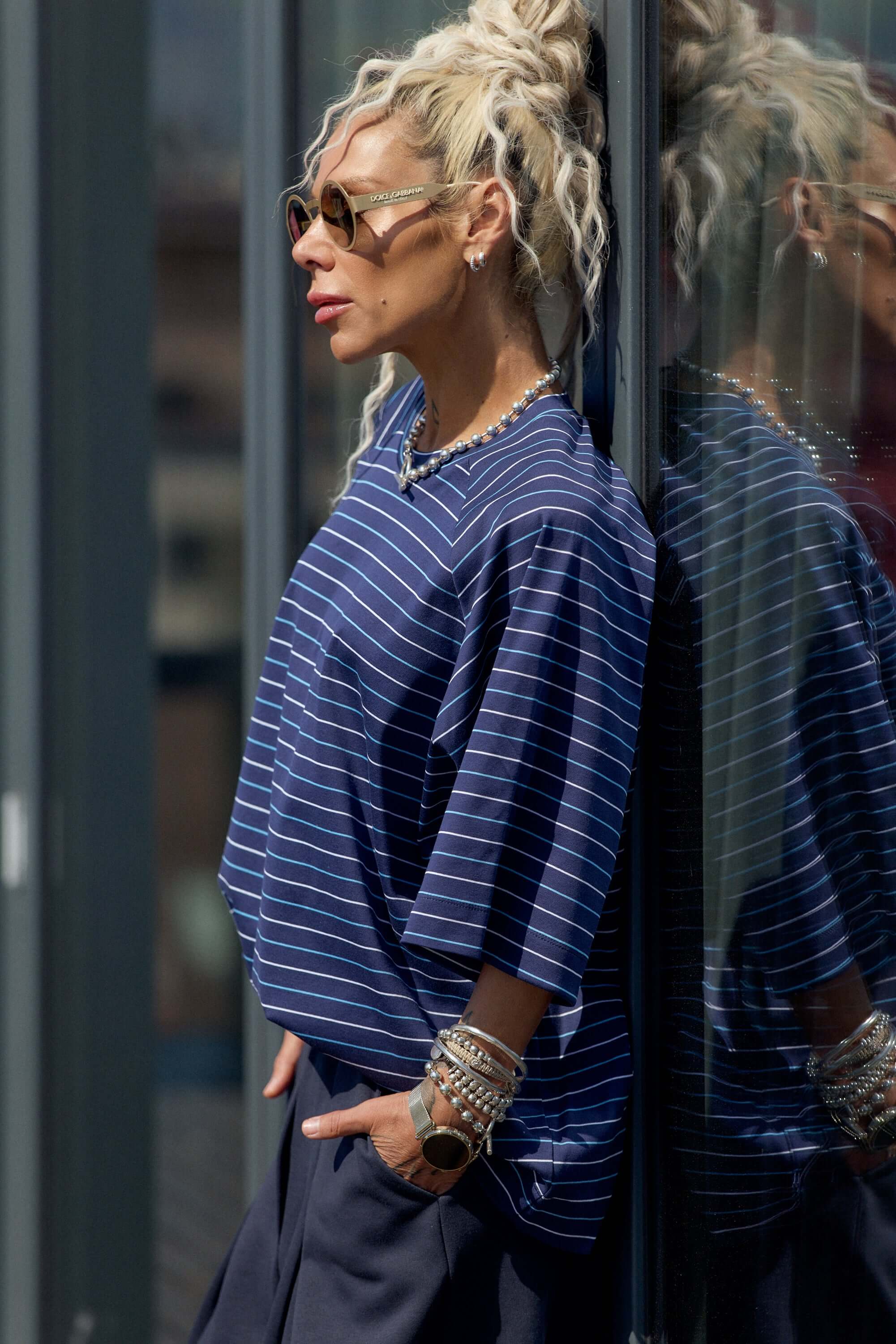 Model wearing an Oversized Striped Set, featuring a striped T-shirt and chic accessories, against a modern background.