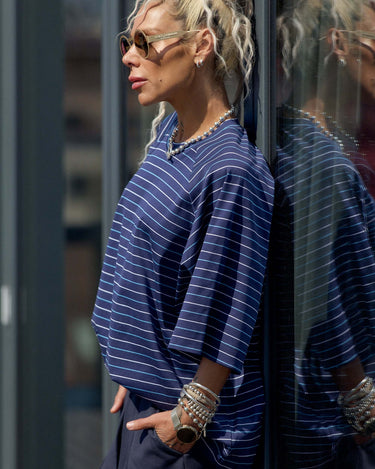 Model wearing an Oversized Striped Set, featuring a striped T-shirt and chic accessories, against a modern background.