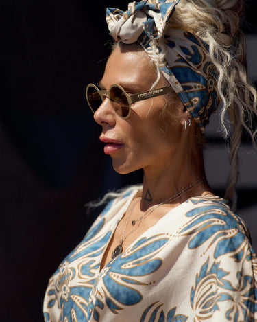 Woman wearing a Printed Bohemian Headband with oversized knot detail and stylish sunglasses.