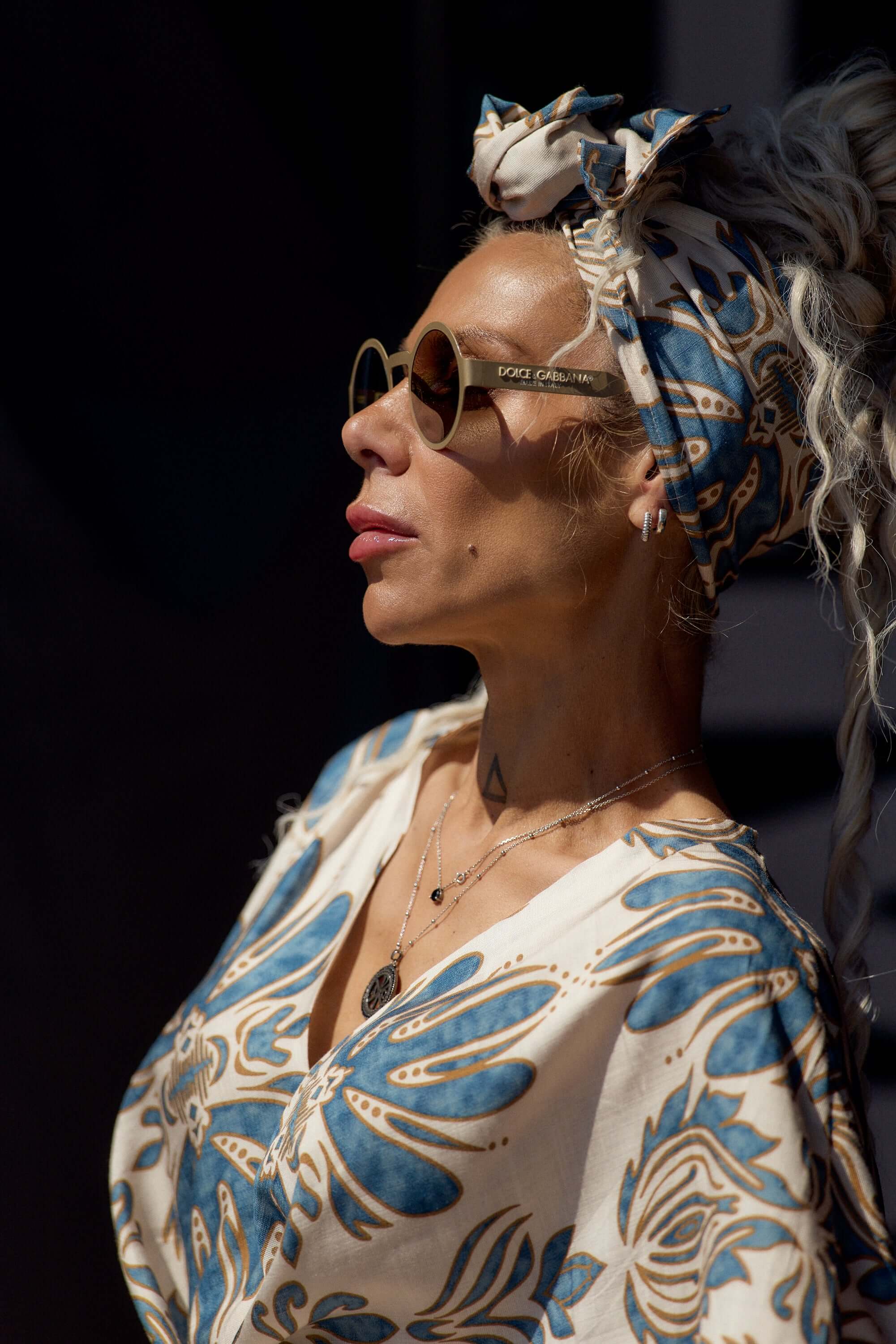 Woman wearing a Printed Bohemian Headband with oversized knot detail and sunglasses, depicting effortless style.