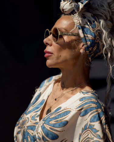 Woman wearing a Printed Bohemian Headband with oversized knot detail and sunglasses, depicting effortless style.