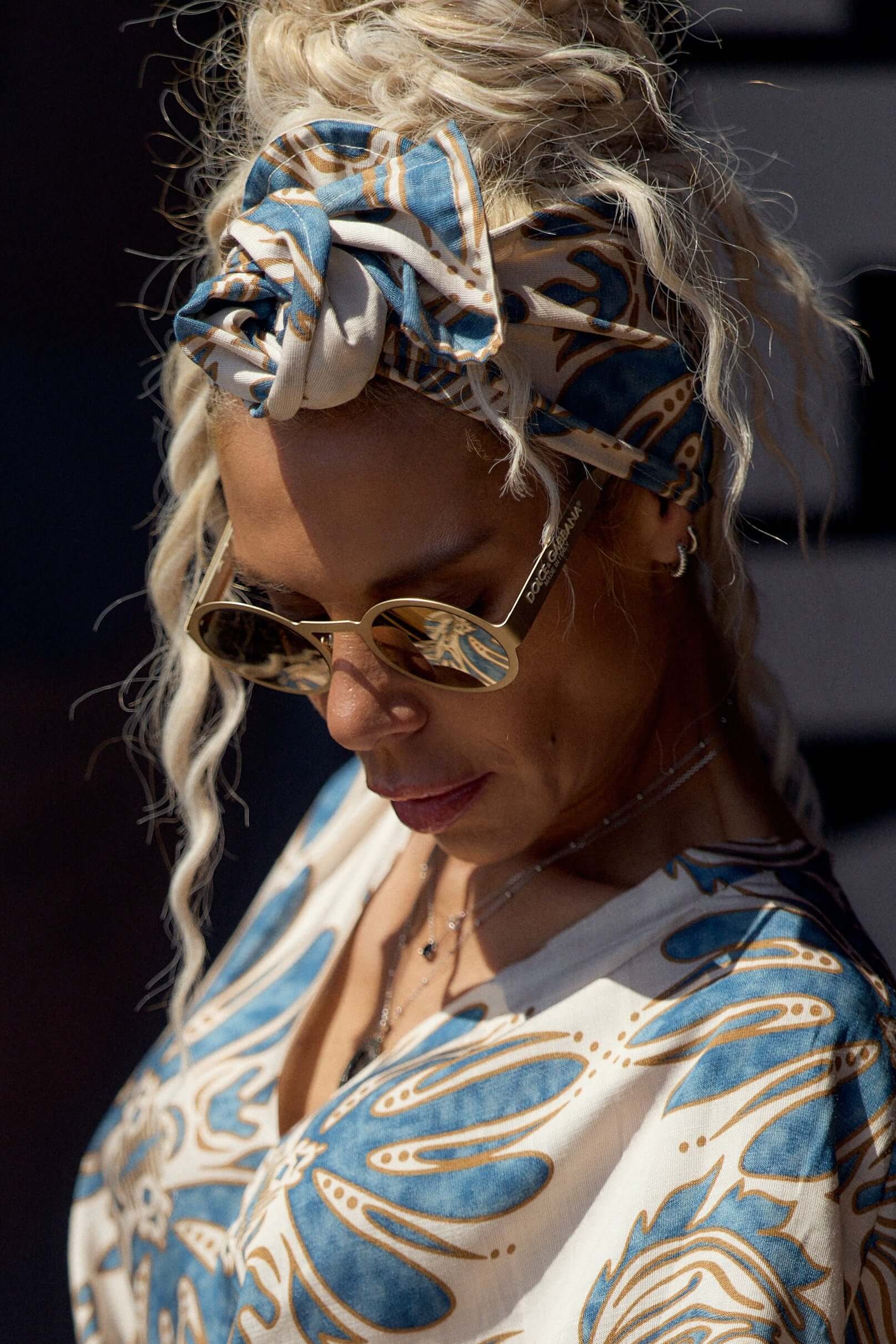Woman wearing a Printed Bohemian Headband with a stylish blouse and sunglasses, showcasing effortless bohemian fashion.