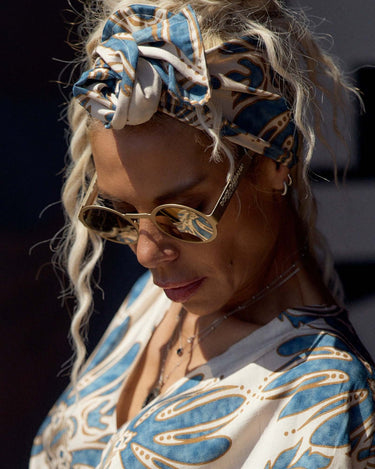 Woman wearing a Printed Bohemian Headband with a stylish blouse and sunglasses, showcasing effortless bohemian fashion.