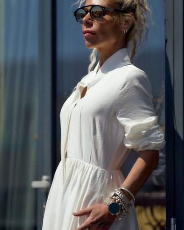 Model showcasing a Flowing White Maxi Dress with stylish sunglasses and accessories.