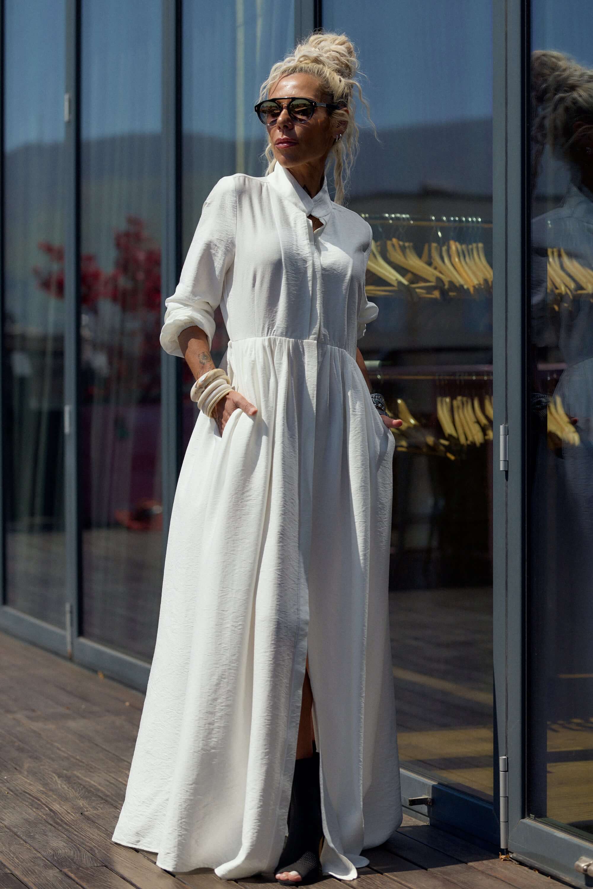 Model wearing a Flowing White Maxi Dress, showcasing its elegant design and fluid movement outdoors.