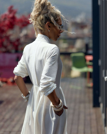 Model wearing a Flowing White Maxi Dress, showcasing its sleek design and fluid movement on a sunny day.