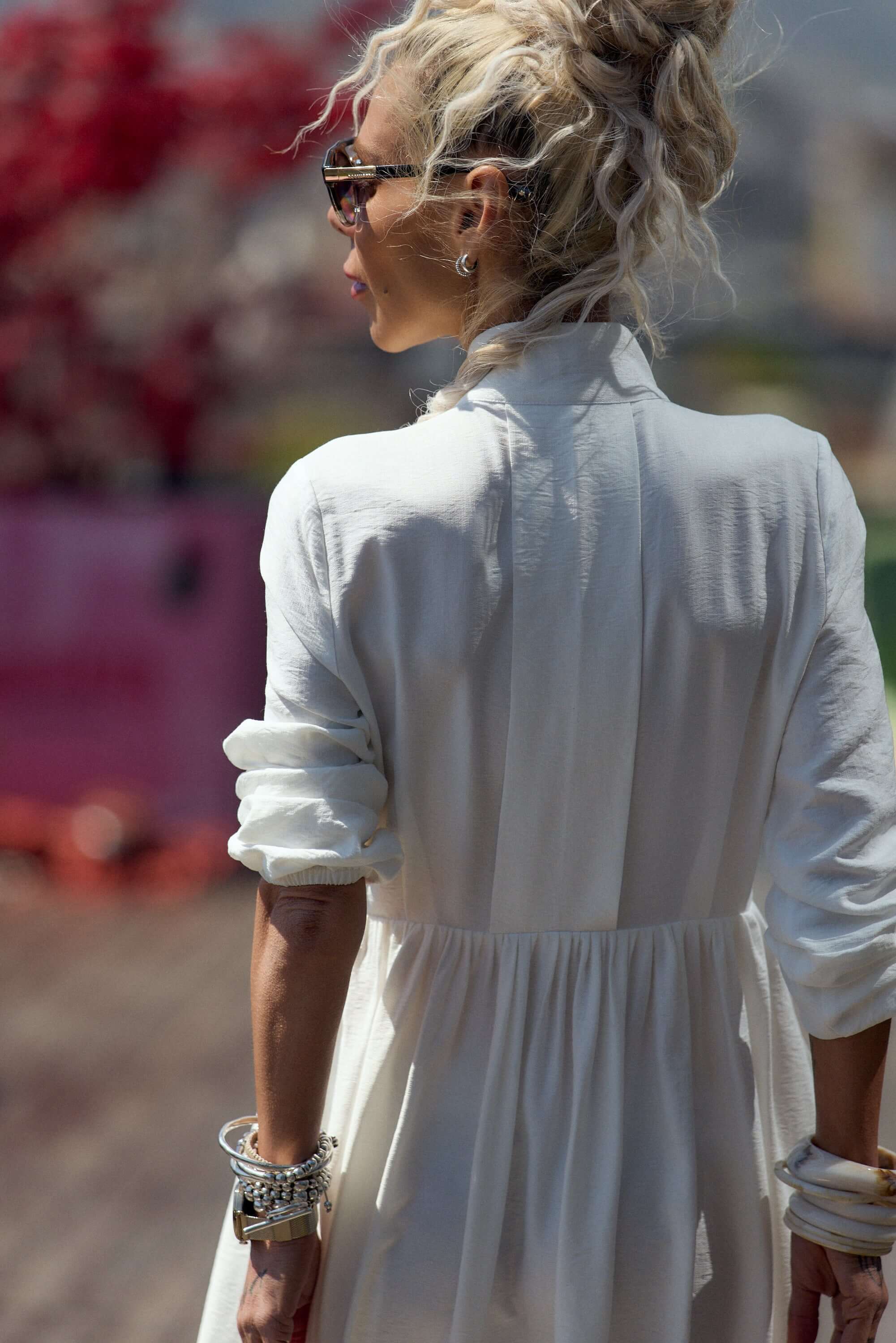 Woman wearing a Flowing White Maxi Dress with a distinctive neckline, showcasing elegant fluid movement outdoors.