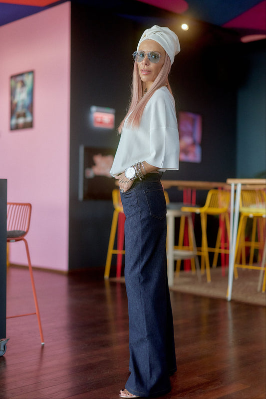 Model wearing Wide-Leg Raw Denim Jeans with a stylish top and accessories in a vibrant setting.