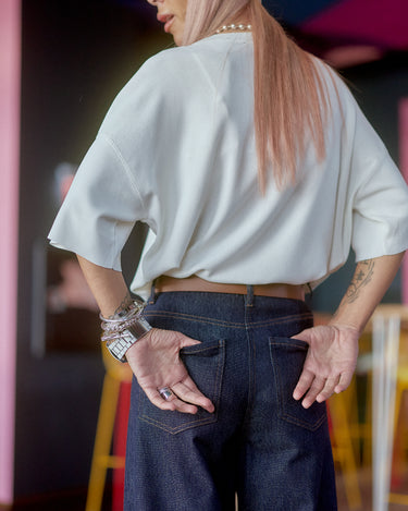 Wide-Leg Raw Denim Jeans worn with a loose white top, showcasing the back view and stylish silhouette.