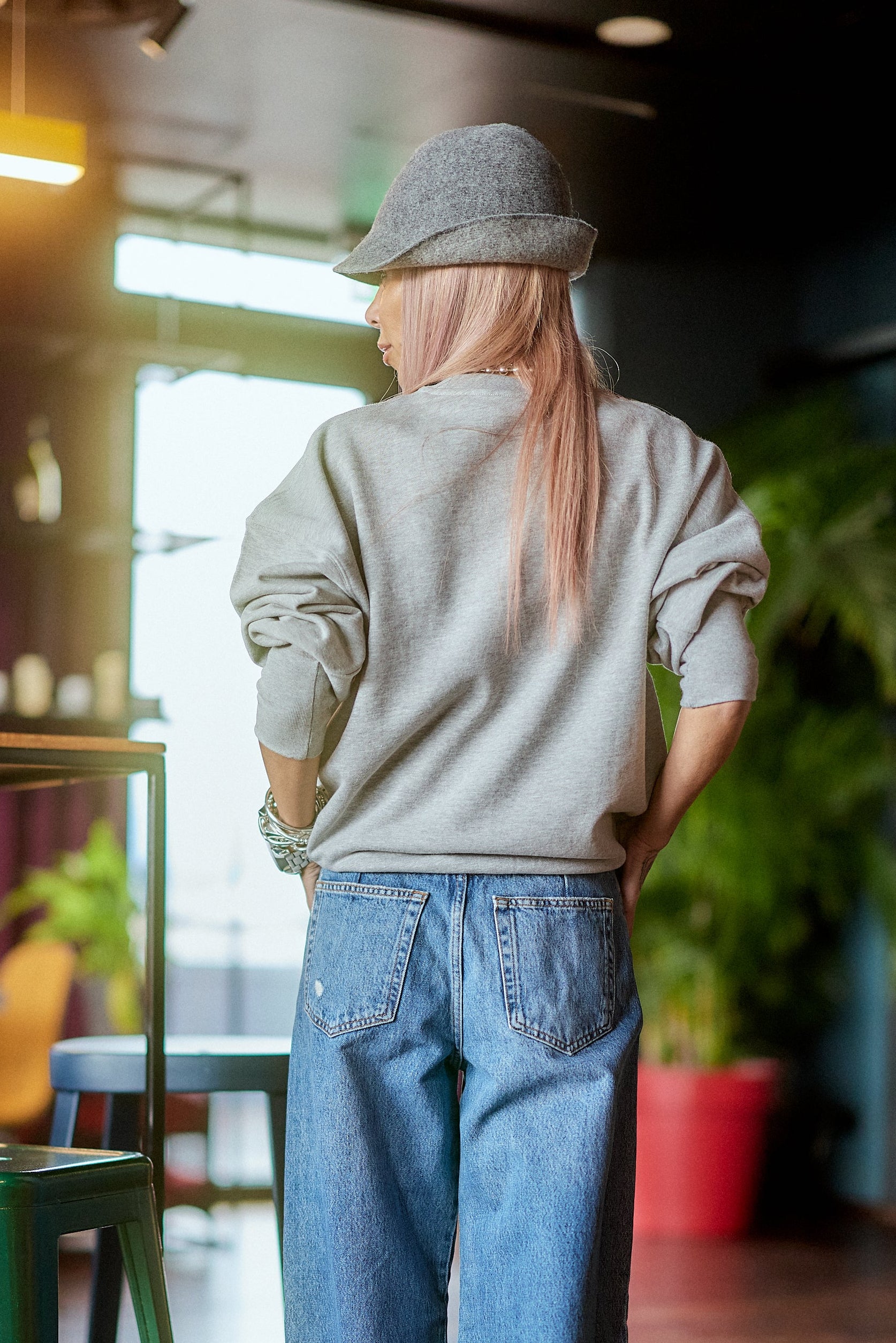 Printed Oversized Blouse Top worn with casual jeans and a hat, showcased in a stylish indoor setting.