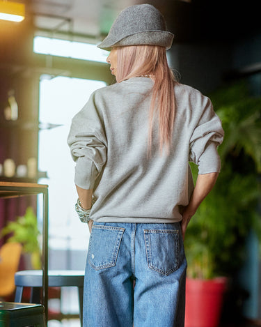 Printed Oversized Blouse Top worn with casual jeans and a hat, showcased in a stylish indoor setting.