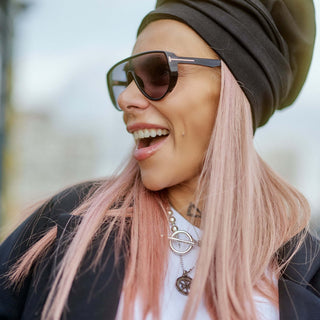 A woman wearing a Black Turban Hat with sunglasses and pink hair, showcasing a stylish urban look.
