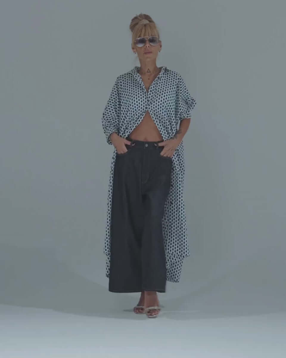 Model wearing polka dot shirt and wide-leg denim jeans, showcasing a trendy and relaxed fashion style.