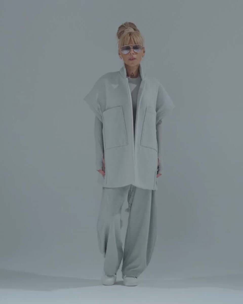 Model showcasing an oversized gray three-piece set with wide-leg trousers and sleeveless vest.