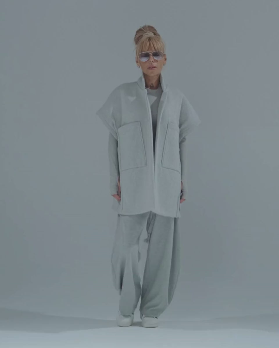 Model showcasing an oversized gray three-piece set with wide-leg trousers and sleeveless vest.