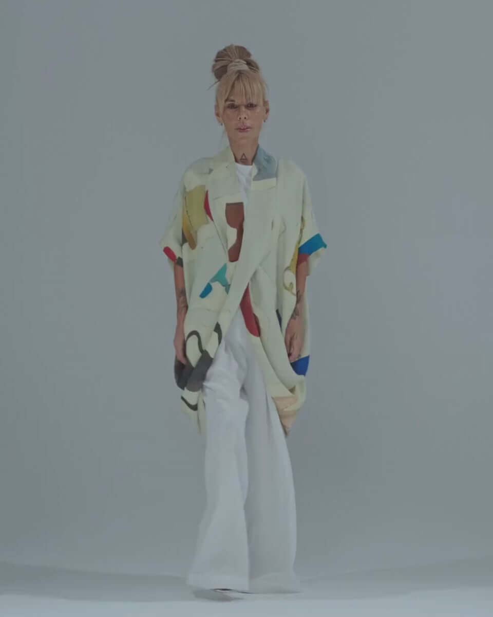 Model showcasing a printed linen blend tunic with an oversized silhouette and multicolor abstract design.