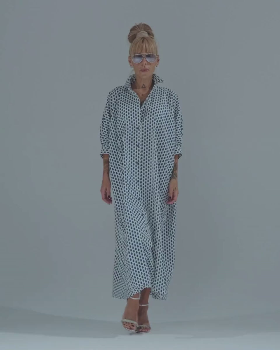 Model showcasing an oversized shirt dress with a polka dot pattern and button-down design.
