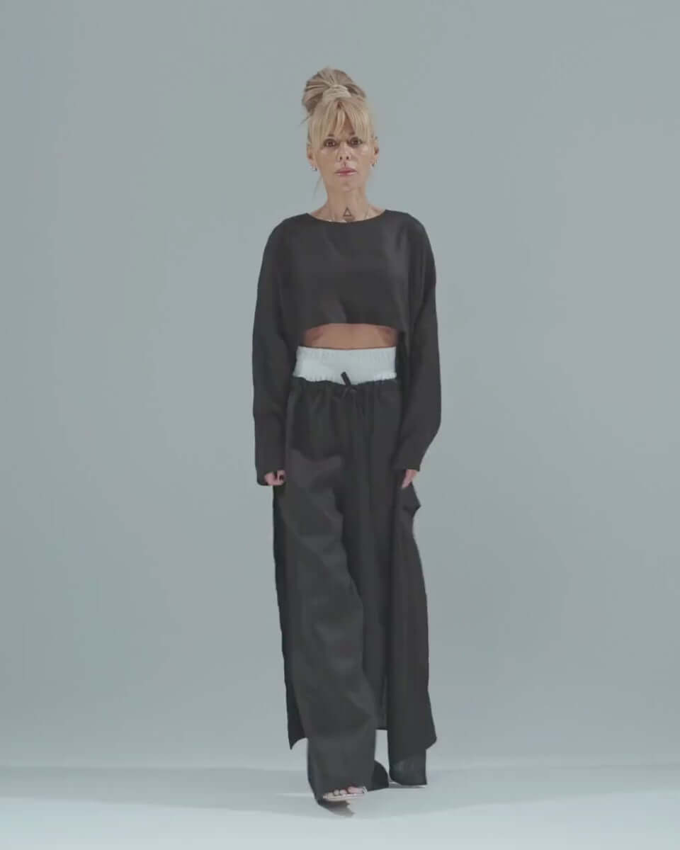 Model wearing a stylish black co-ord set with a cropped tunic and wide-leg pants.