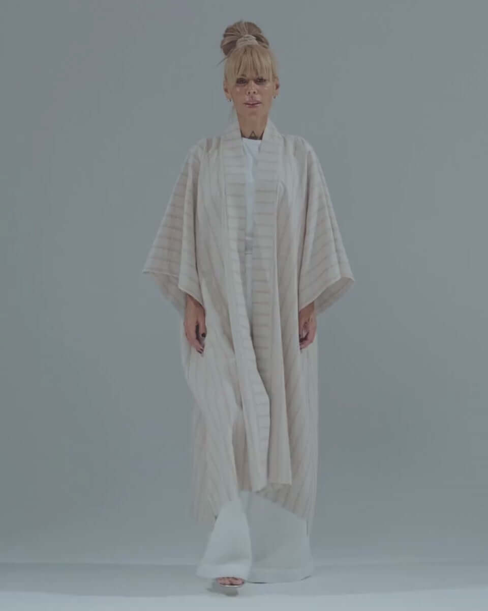 Woman modeling a lightweight striped linen-cotton kimono, showcasing its relaxed fit and elegant drape.