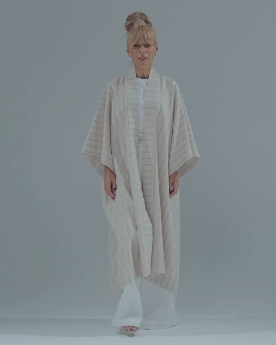 Woman modeling a lightweight striped linen-cotton kimono, showcasing its relaxed fit and elegant drape.