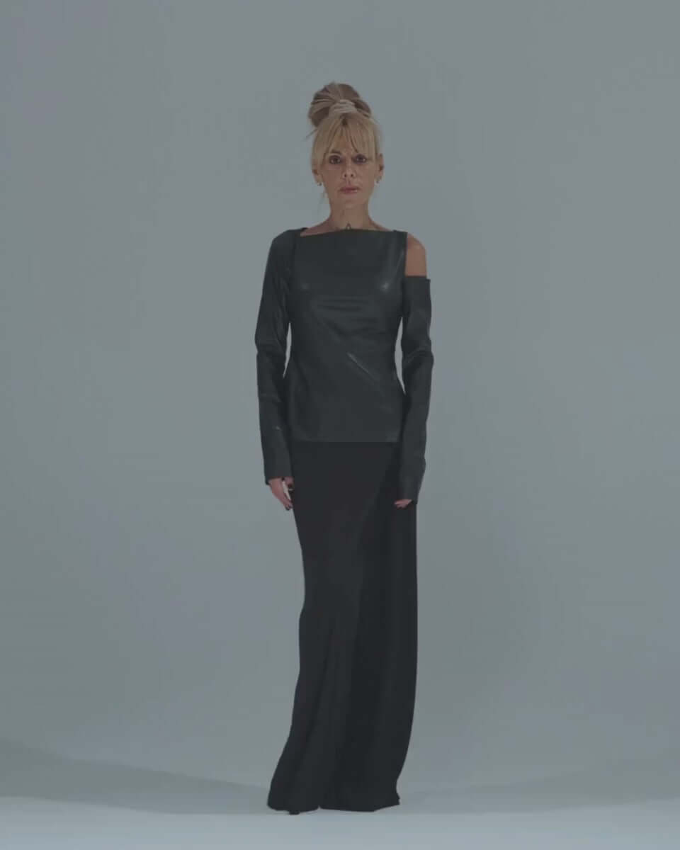 Black faux leather top with cut-out shoulder details, paired with a sleek long skirt for an elegant look.